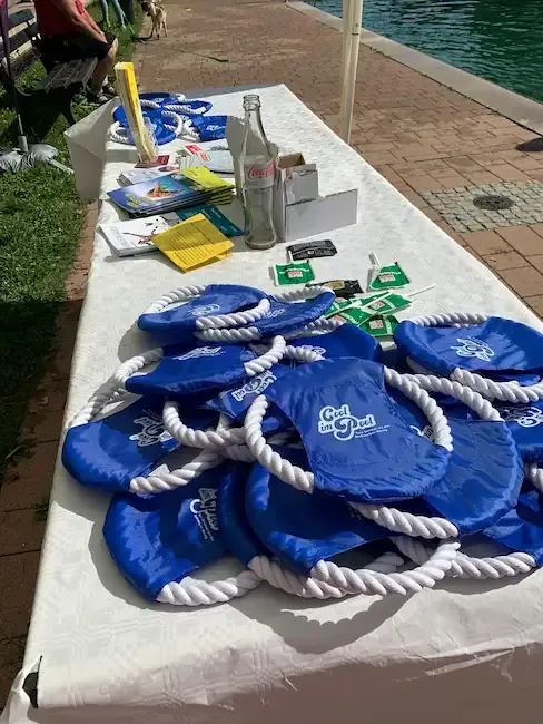 Hundeschwimmen: Tisch mit blauen Wurfspielzeugen für die Teilnehmer